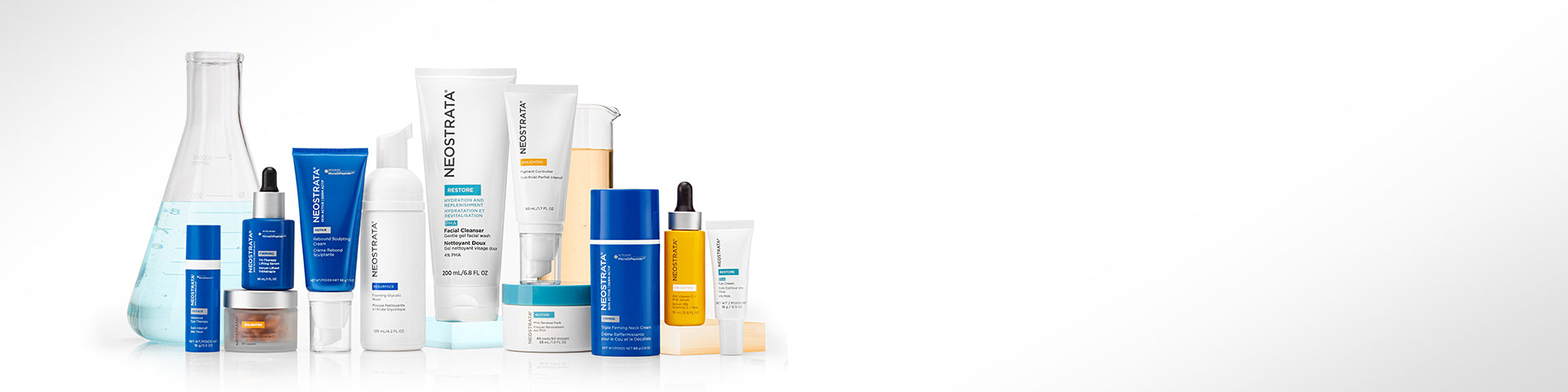 An array of bottles of Neostrata Skincare and beakers, on a white background.